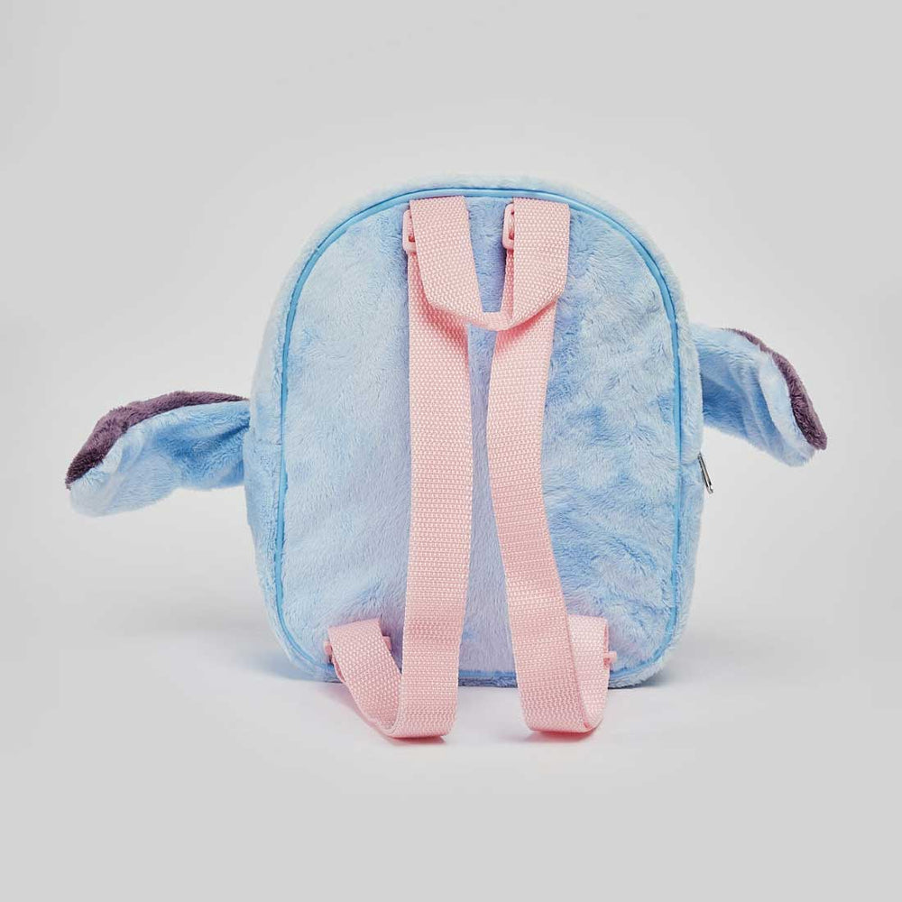 A plush character backpack shaped like Stitch, shown from the back. The backpack is light blue with pink straps and darker purple inner ears, set against a plain light gray background.