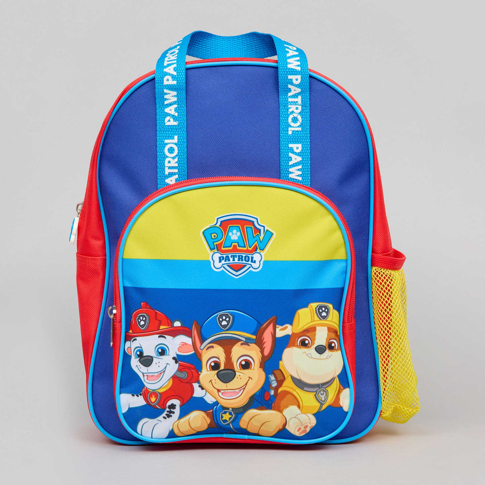A Paw Patrol school backpack featuring blue, red, and yellow panels, with Paw Patrol character graphics on the front pocket and branded shoulder straps.