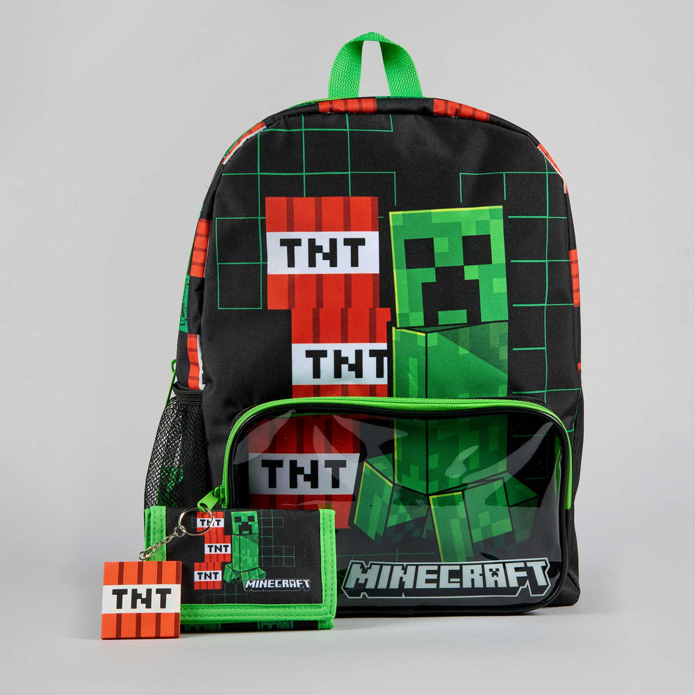 A black Minecraft backpack with green and red block graphics, a green Creeper character print, and a front zip pocket with a clear window. A matching keychain and card holder are placed in front on a light gray studio background.