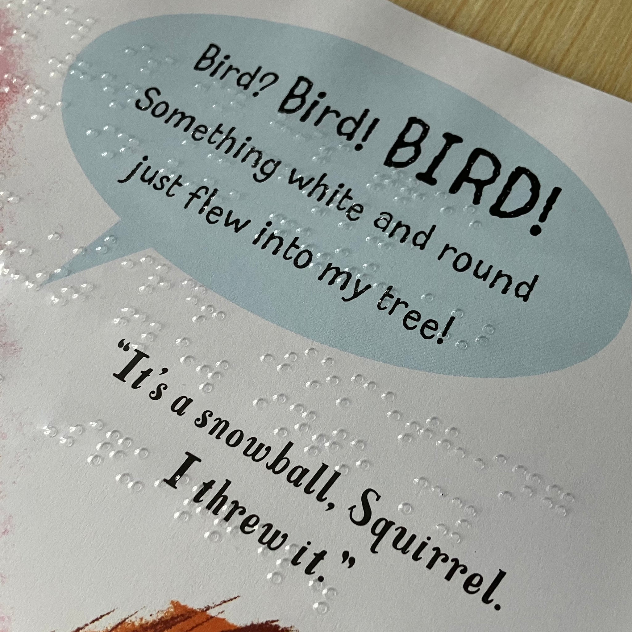 Close-up of transparent braille over printed text and image