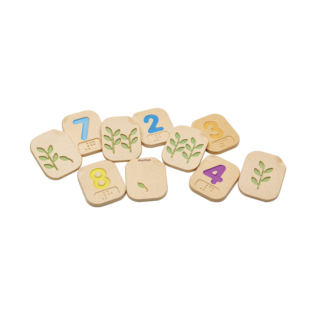 Jumble of braille number tiles, some showing a colourful number, others showing a plant with a specific number of leaves