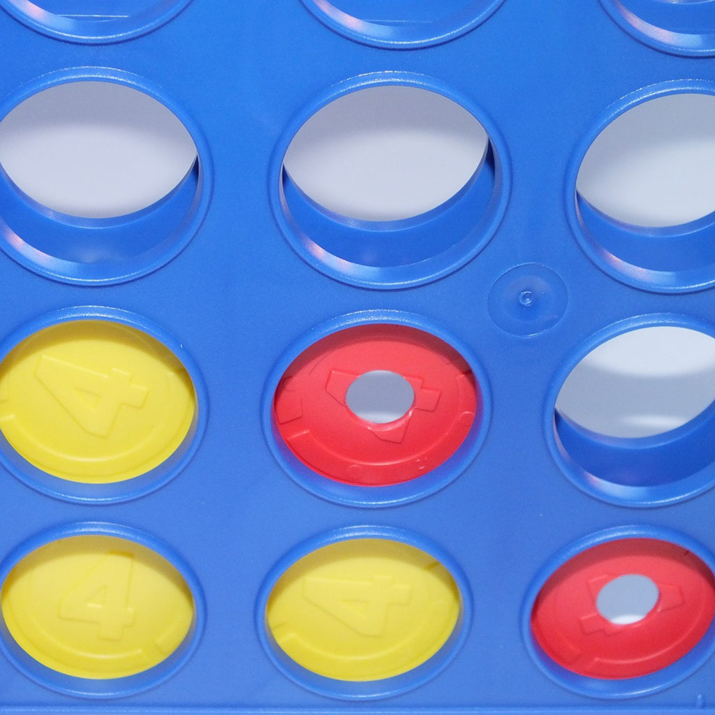 Close up of the Connect 4 frame with red and yellow discs in place. The red discs have a hole in the middle and the yellow counters do not.