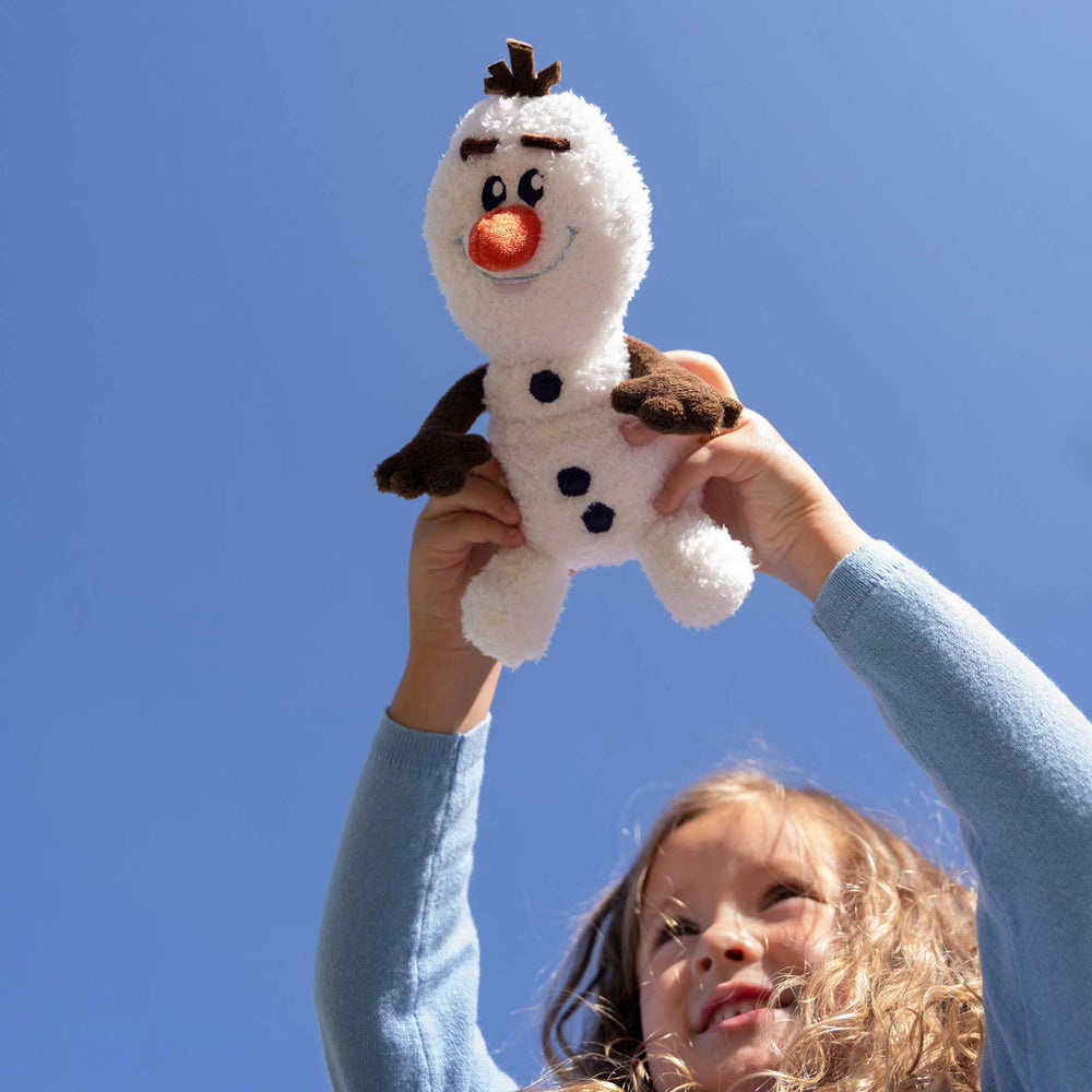 Child holding a plush toy against a clear blue sky
