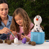 Woman and young girl painting pinecones with a plush toy in the background