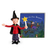 Toy figure of a witch with a broom and a book titled 'Witch on the Broom' on a white background