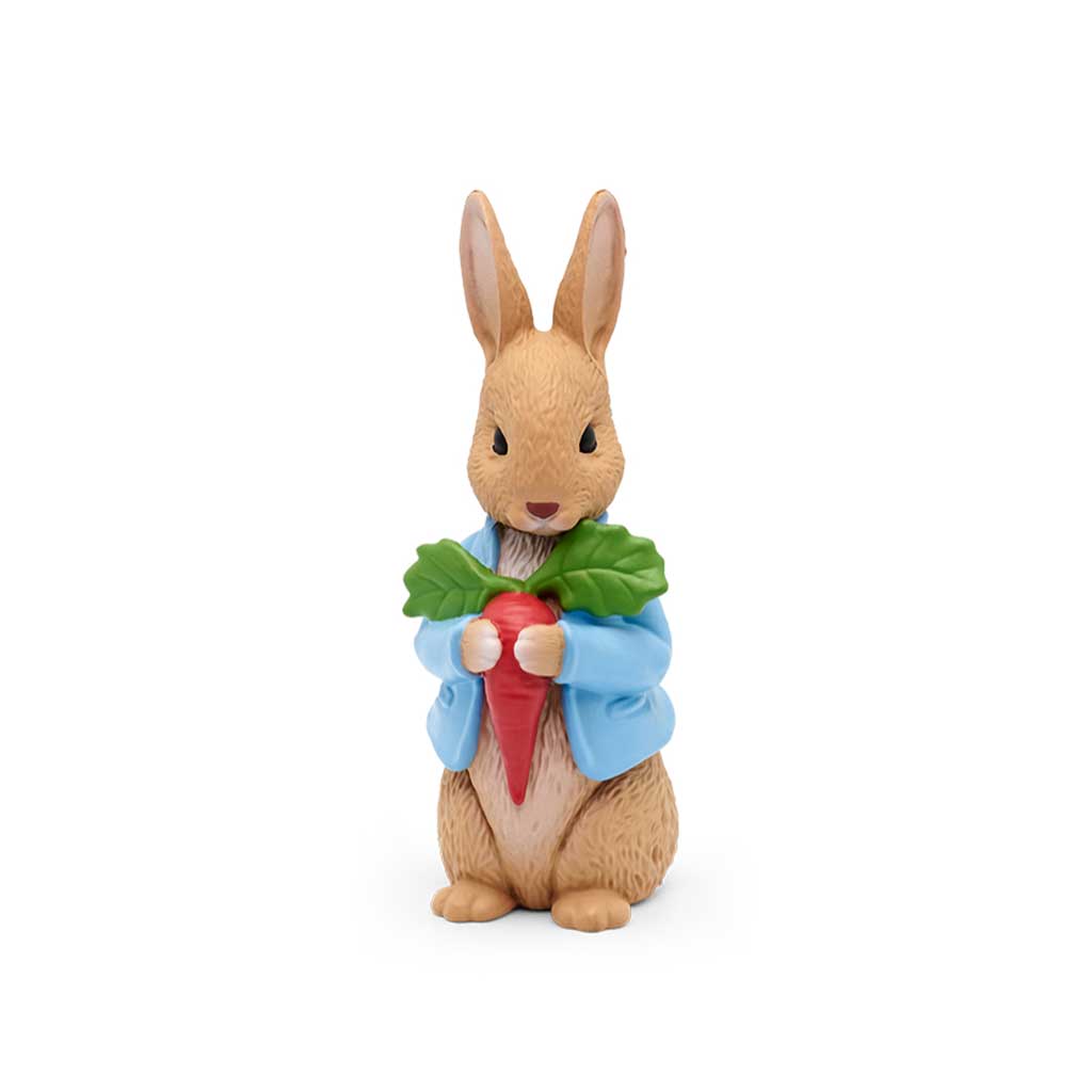 Figurine of a rabbit holding a carrot and leaves on a white background