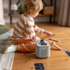Child playing with a small robot on a wooden floor