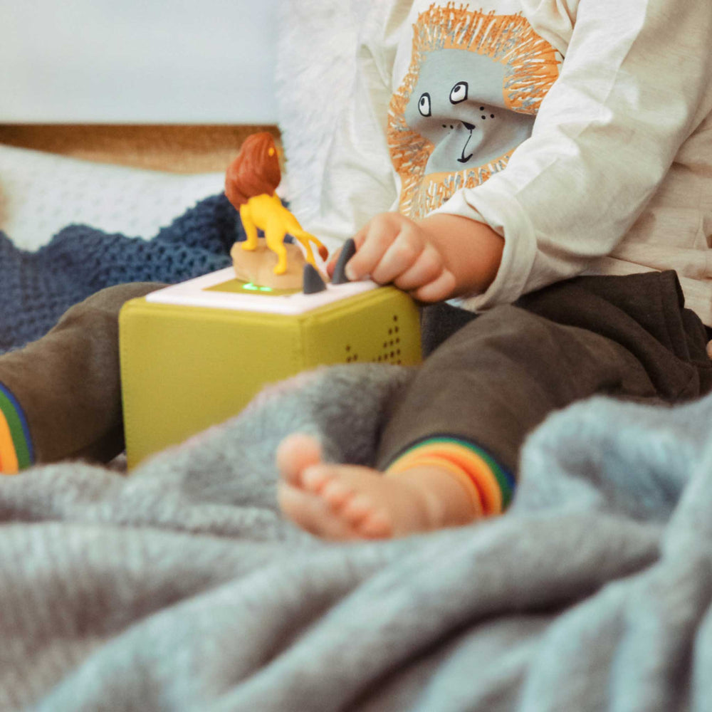 Child playing with a toy on a bed
