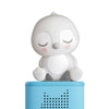 White cartoon-like penguin on a blue rectangular base with speaker holes on a white background