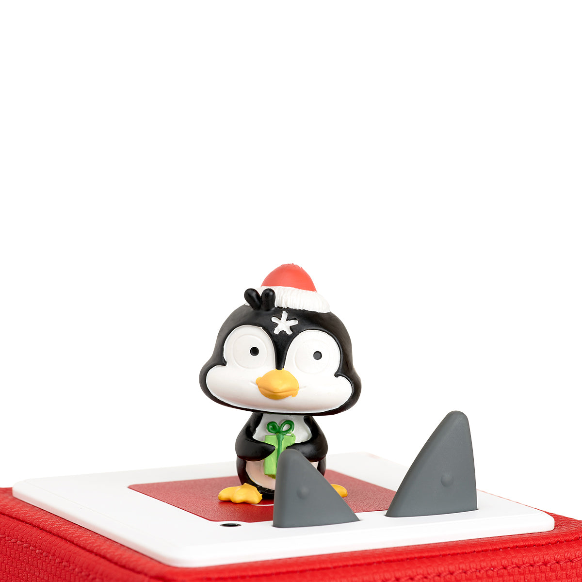 Penguin figurine with a Santa hat on a red Toni box