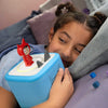 Child playing with Toniebox 2 featuring a red character on a bed.