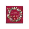 Christmas card with wreath design featuring birds and flowers on a red background