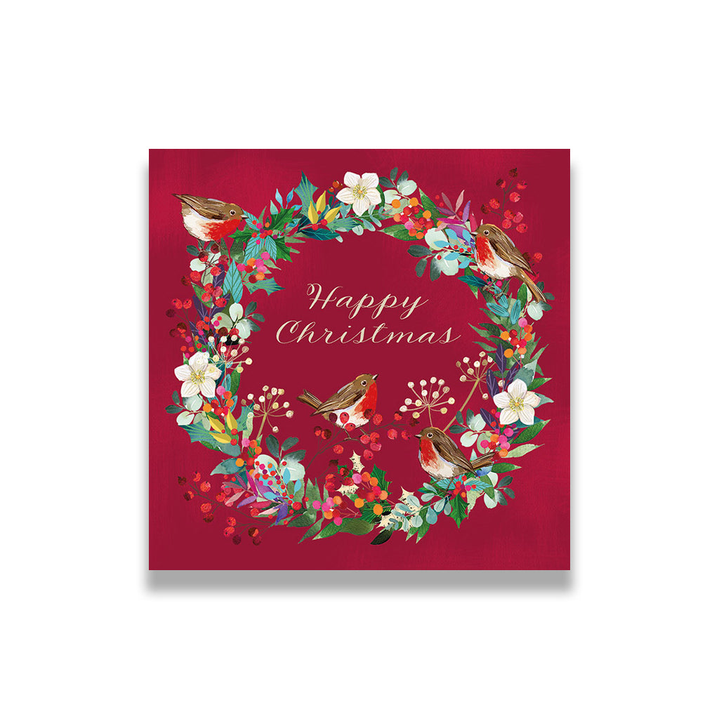 Christmas card with wreath design featuring birds and flowers on a red background