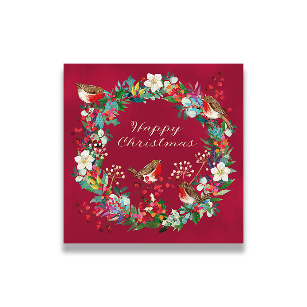 Christmas card with wreath design featuring birds and flowers on a red background