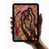 Hand holding the Apple iPad Air with an image of a person wearing a patterns dress with orange flower motive.