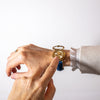 Watch on wrist with lid open and a finger pointing at dial
