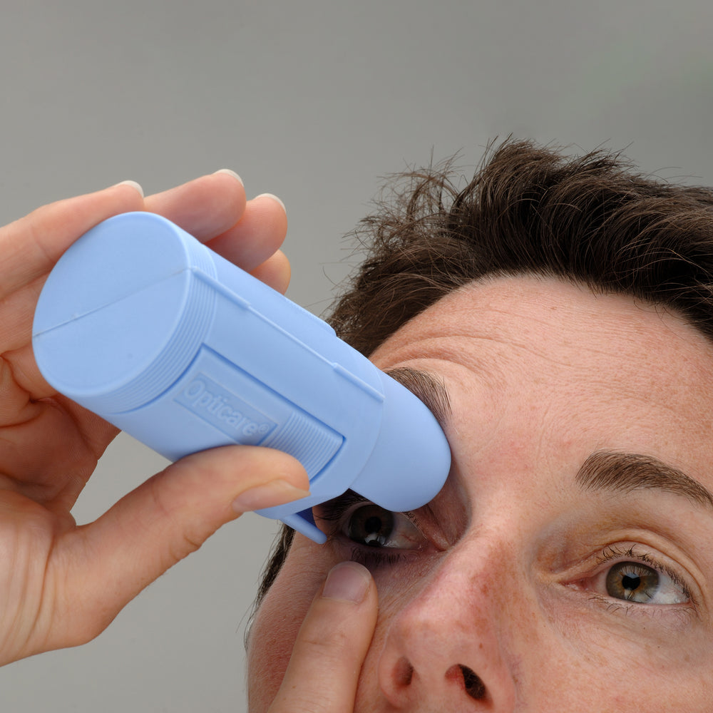 Someone using the dispenser to apply eye drops