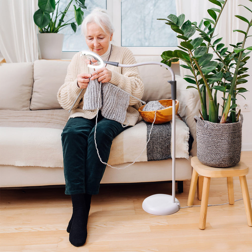 A woman using the light while knitting