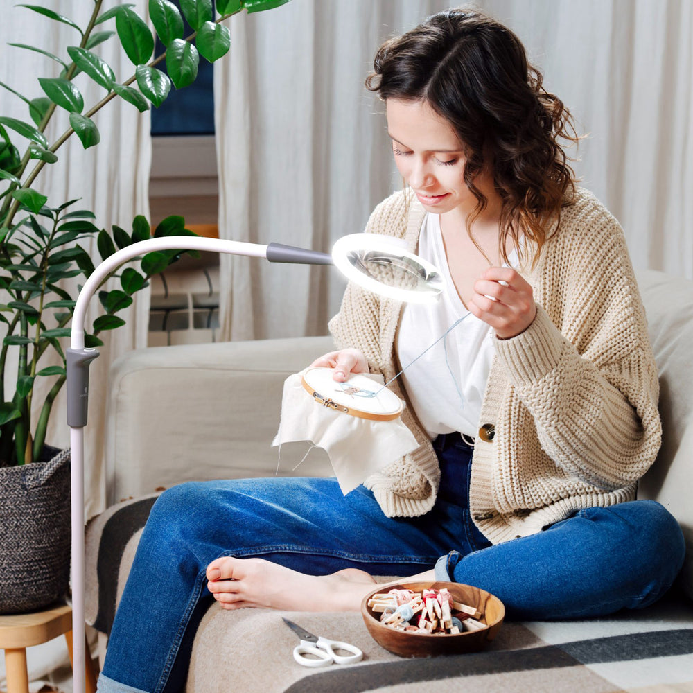 A woman using the light while sewing