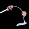 Hands adjusting the Daylight UnoPro table lamp against a black background