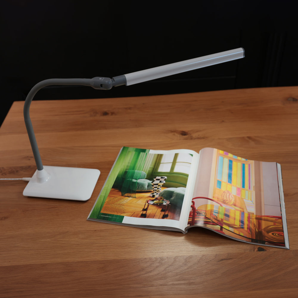 UnoPro light on a table illuminating a magazine