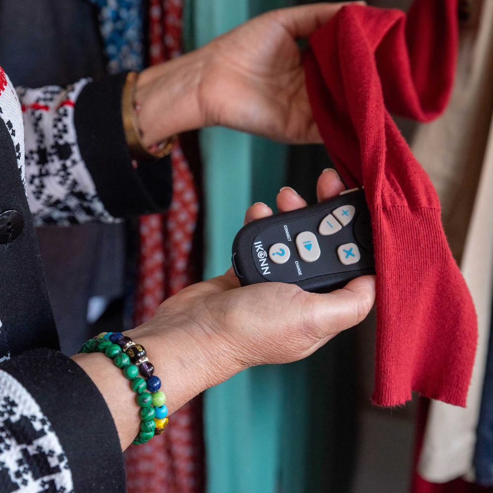 Person using the IKONN controller with colour sensor attached to determine the colour of a red item of clothing