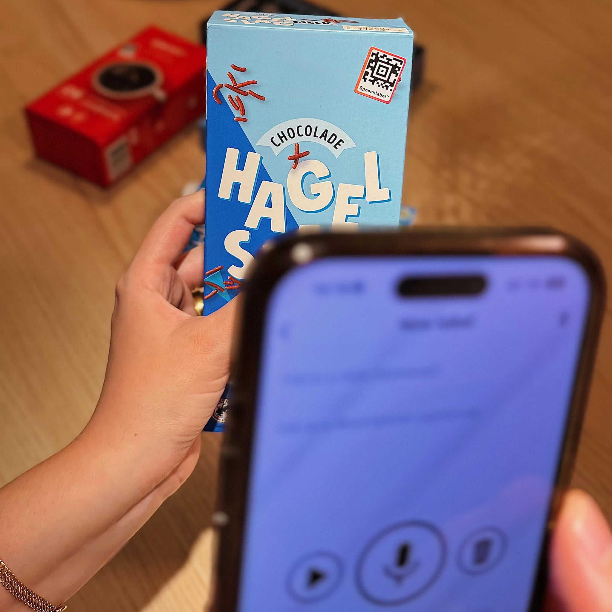 Person holding a box and scanning the QR code with a smartphone.