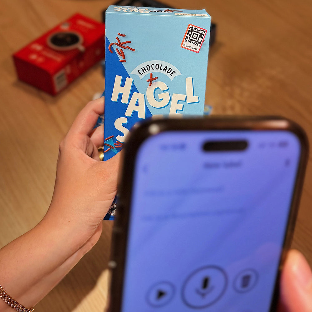 Person holding a box and scanning the QR code with a smartphone.