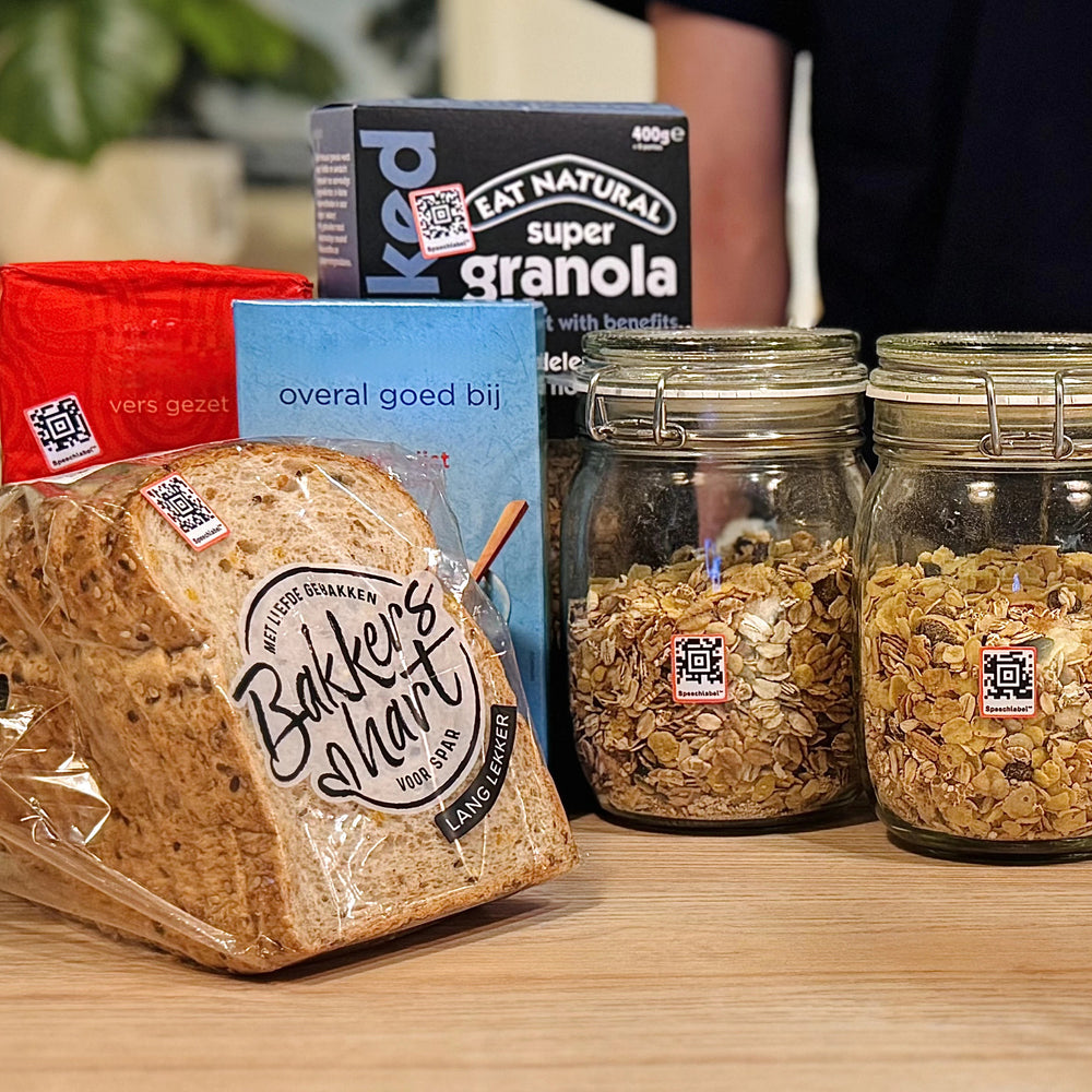 Various food products, including bread and cereals in jars with small Speechlables stuck to each for identification.