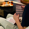 Person holding a pack of QR codes on a blurred indoor background