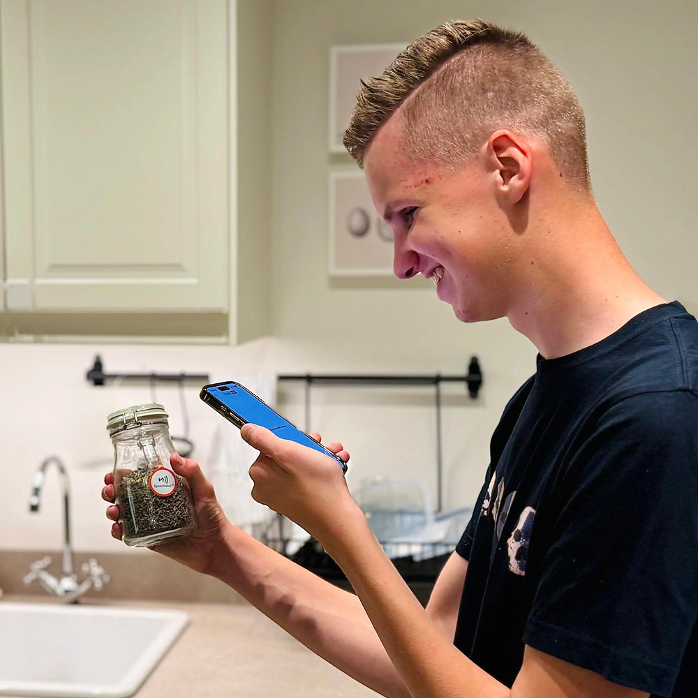 Person holding a jar of spices and scanning the label with a smart phone.