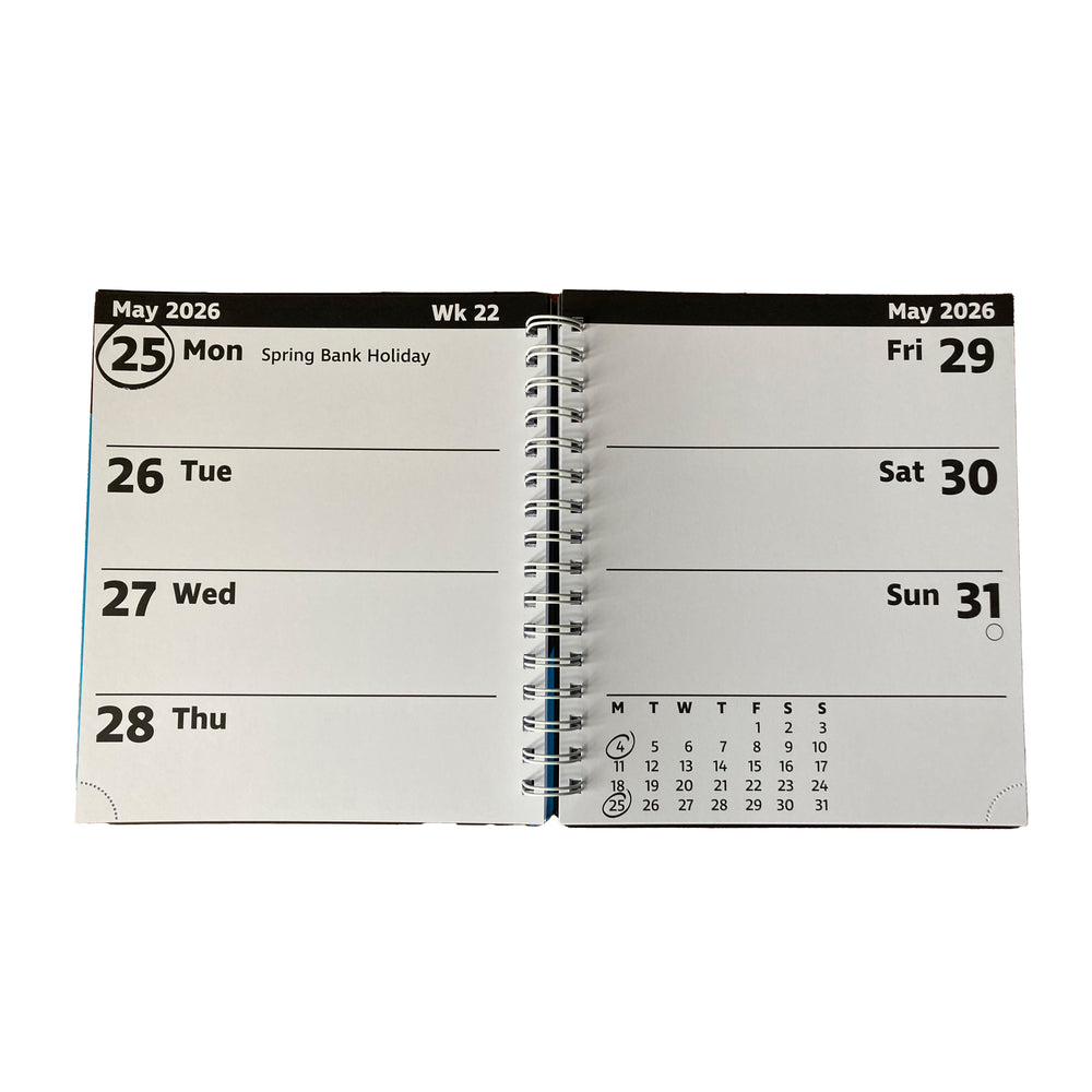An open spiral-bound planner showing the weekly layout for May 2026, with days Monday through Sunday listed on white pages against a black header strip.