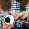 Person using the tape measure to measure a piece of clothing.