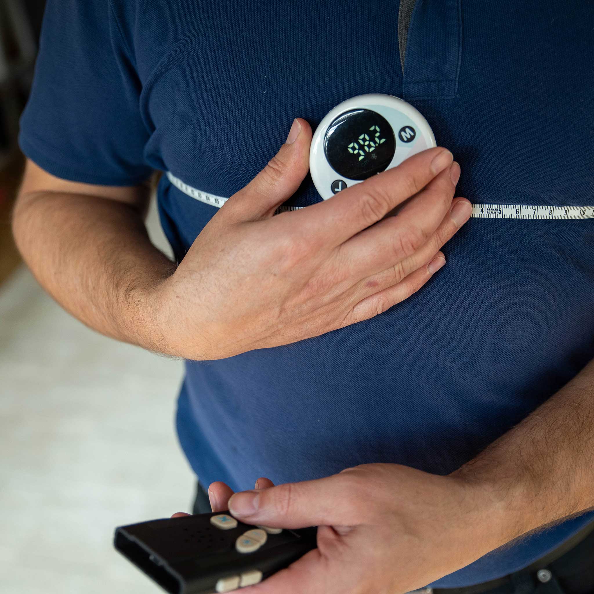 Person using the tape measure to measure their chest. 