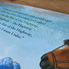 Book page with horse illustration and text, featuring Braille.