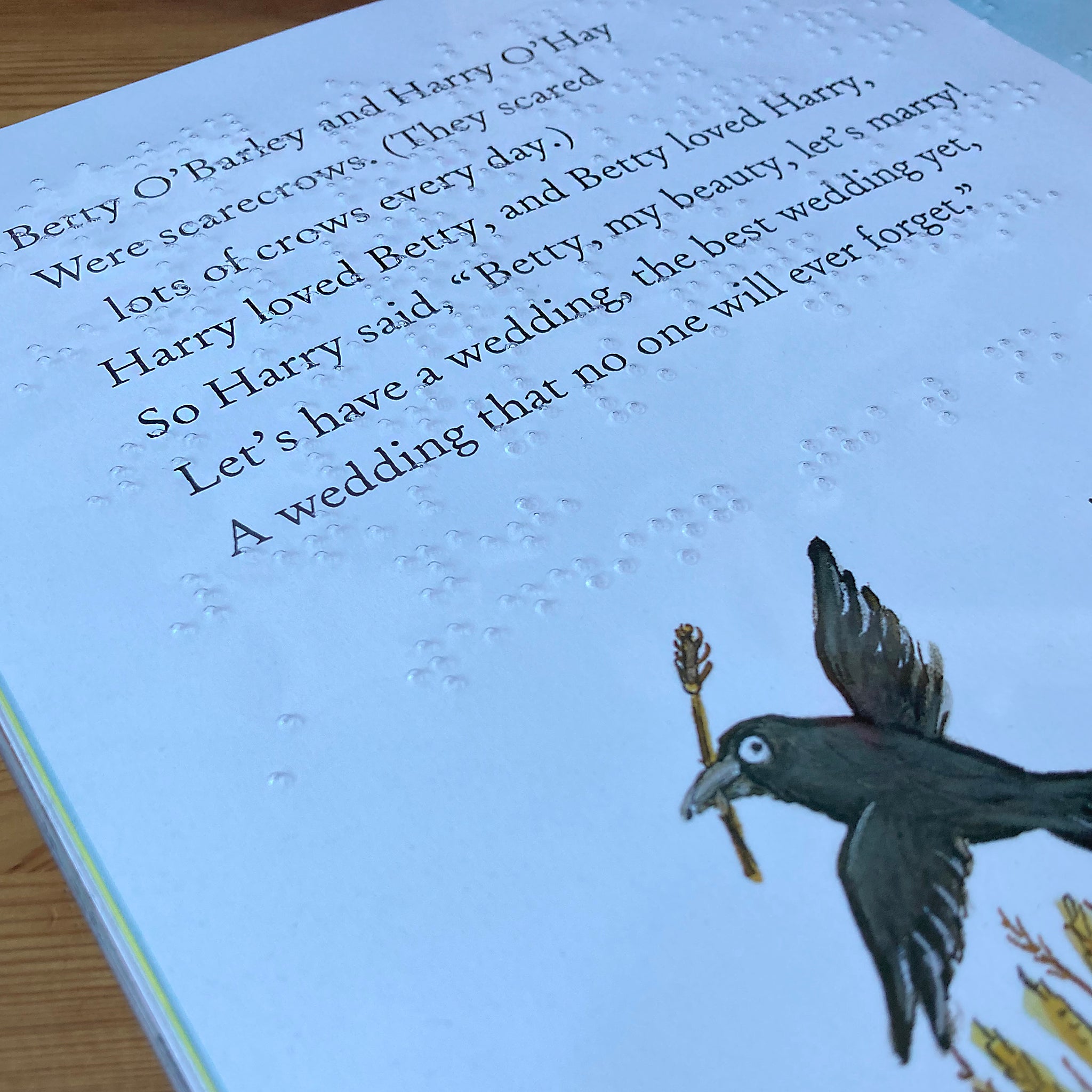 Book page with text and braille and a illustration of a crow holding an anvil.