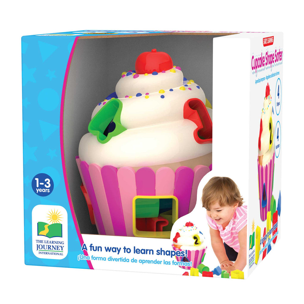 Cupcake Shape Sort toy in its retail packaging, featuring a cupcake-shaped sorting board with colorful frosting swirls and a small child pictured on the box.