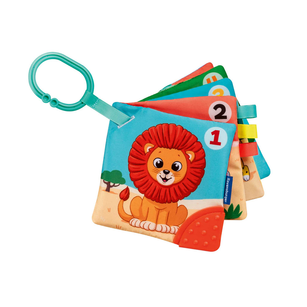 A colorful baby sensory toy book with a teal ring handle, featuring a lion illustration on the front and numbered fabric tabs.