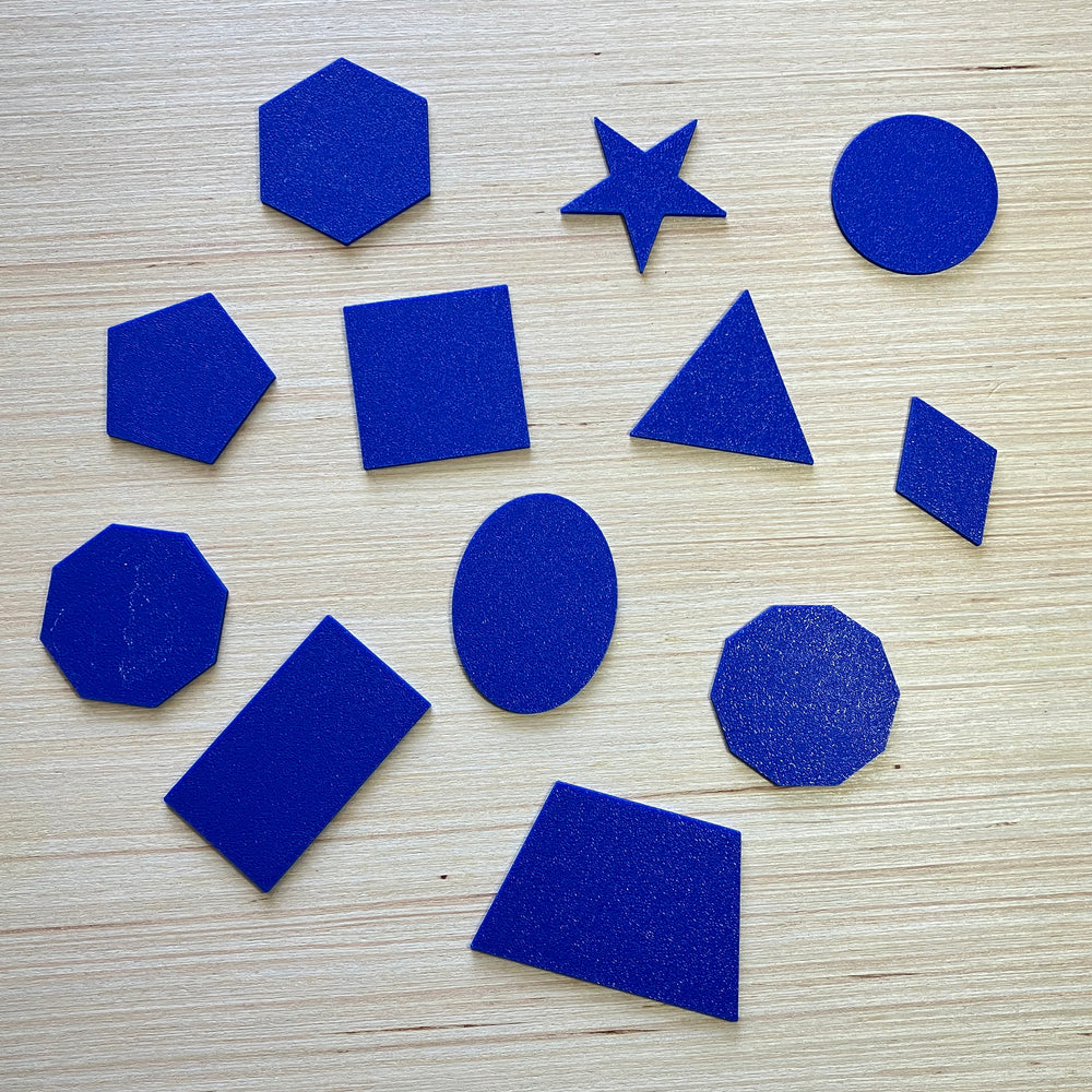 Blue  3D tactile shapes on a wooden table top.