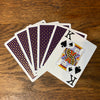 Six cards fanned out on a table showing the blue backs and one showing its face