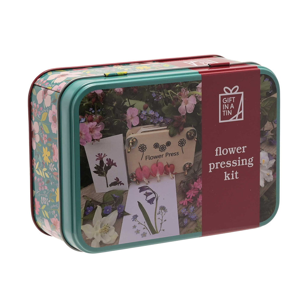 Flower pressing kit in a decorative tin with floral designs and text.