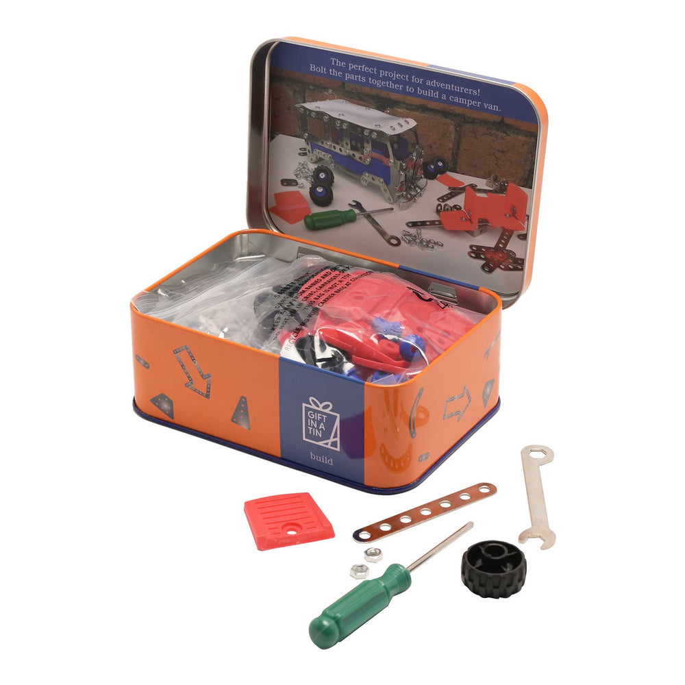 Toy construction kit in an open tin with tools and parts on a white background