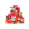 A holiday gift hamper bundle of assorted gourmet snacks, cookies, and treats arranged in a pyramid stack on a white background. The packaging is predominantly festive red with green accents, and the visible brands include Snickers, The Sweethearts, Joe Sept's, and Pillsbury.