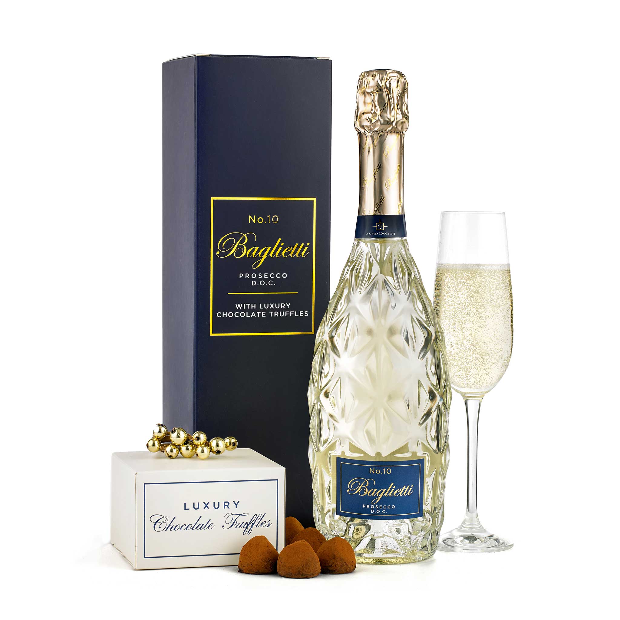 A luxury gift set featuring a bottle of Baguetti No.10 Prosecco, a tall dark blue presentation box, a filled champagne flute, a small box of Baguetti chocolate truffles, and a few truffles placed in front, all on a clean white background.
