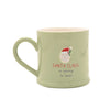 A light sage green ceramic mug with a handle, featuring a graphic of Santa Claus and the text 'SANTA CLAUS is coming to town' on a plain white background.