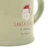 Close up of a light sage green ceramic mug with a handle, featuring a graphic of Santa Claus and the text 'SANTA CLAUS is coming to town' on a plain white background.