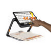 Someone swiping on the touchscreen to move the magnified image of a newspaper. Graphic arrows have been added to show the movement.