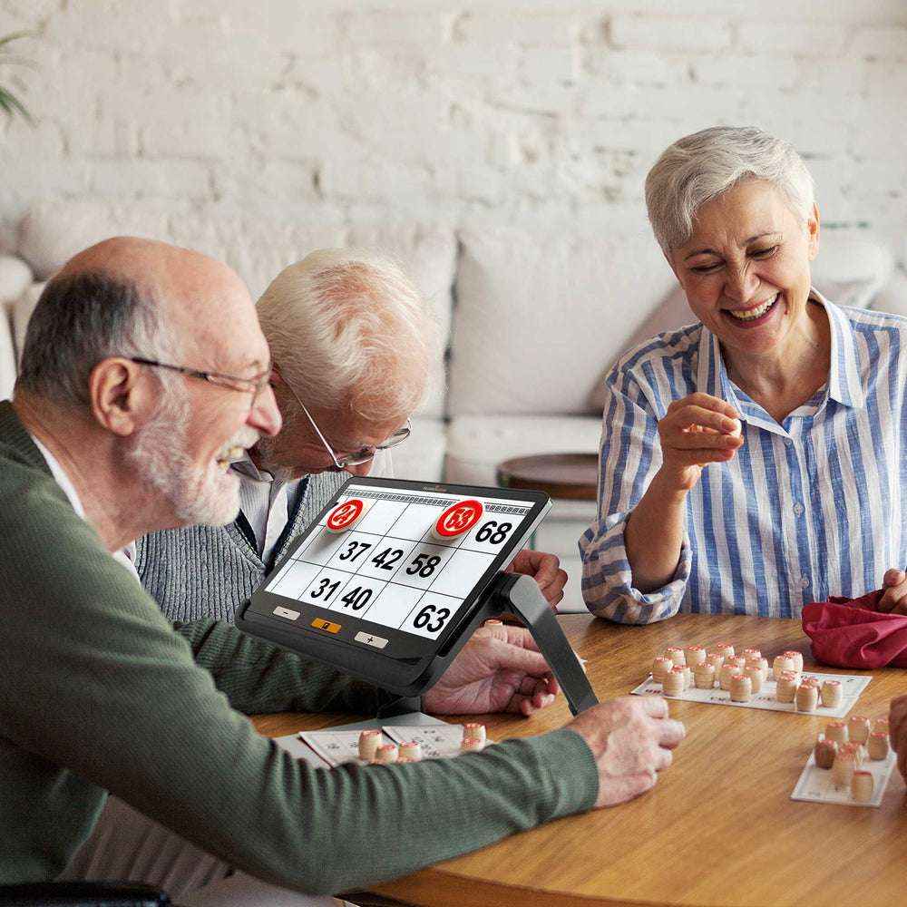 An older man uses the Explore 12 to help him play bingo with friends