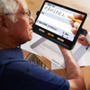 An older man uses the Explore 12 to help him fill in a form