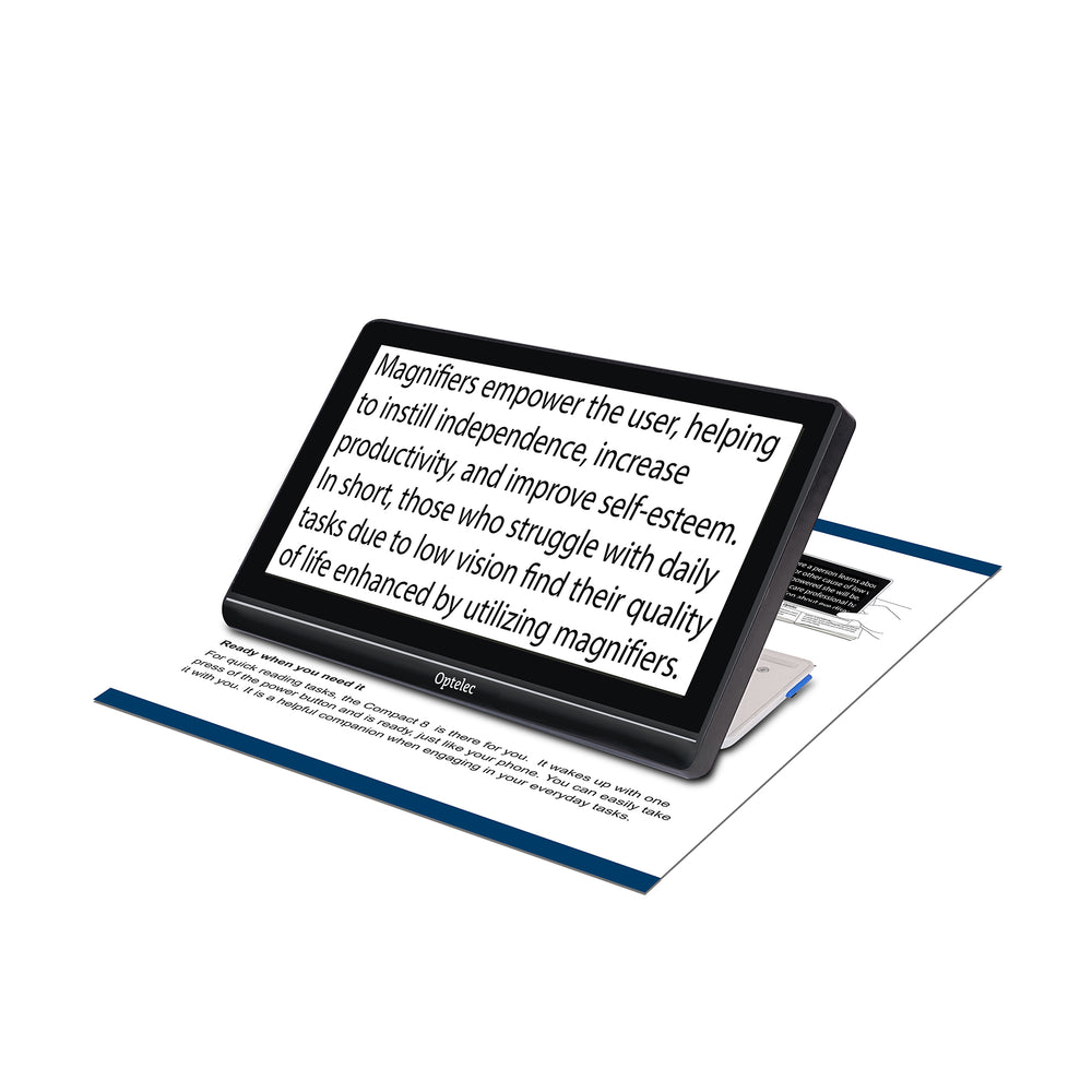 Angled front view of a Compact 8 HD sitting on a sheet of text and showing magnified text on screen in black on white format